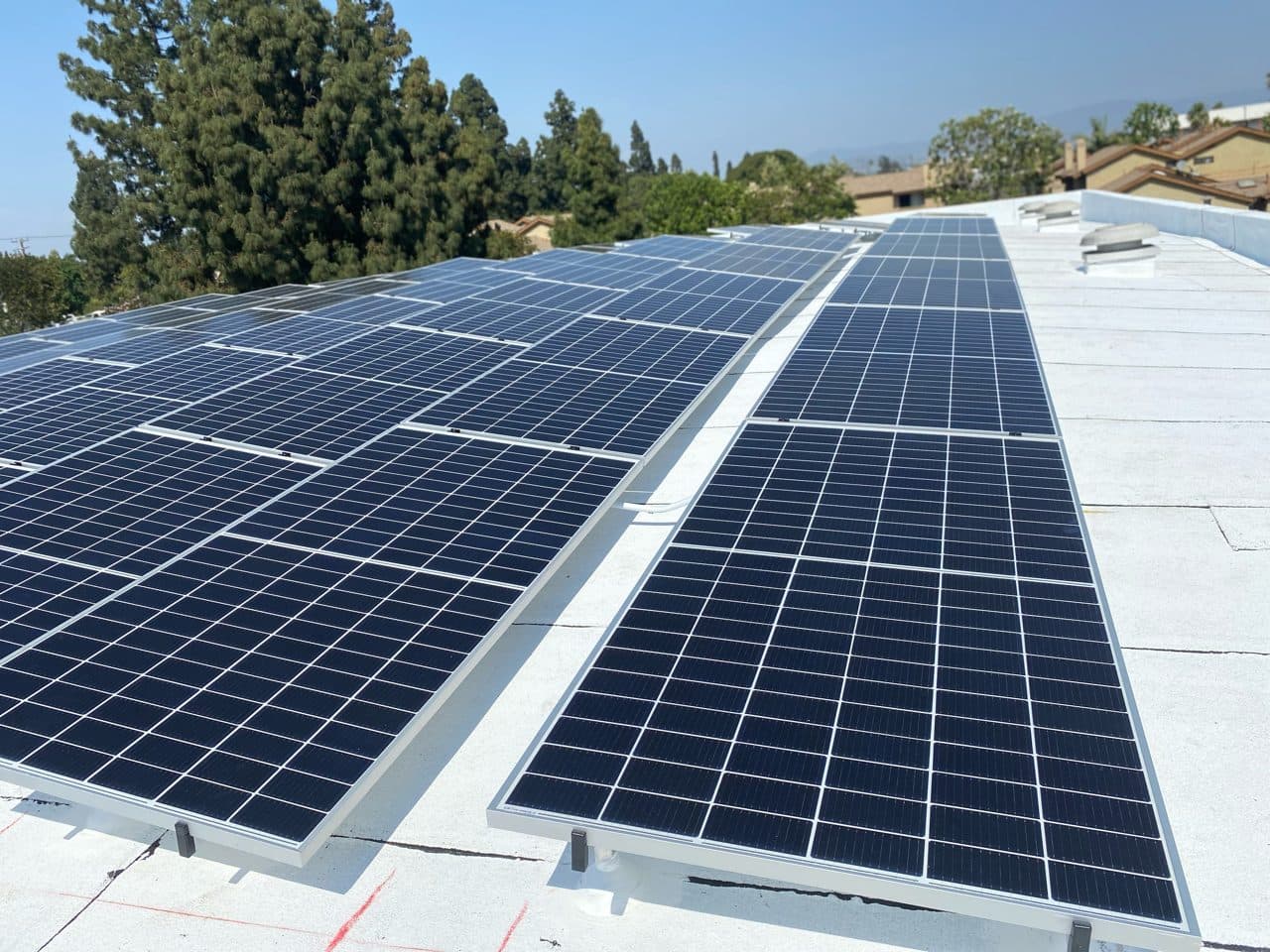 Multi-row commercial solar array on a white membrane roof in Anaheim, CA installed by Helios Energy Global