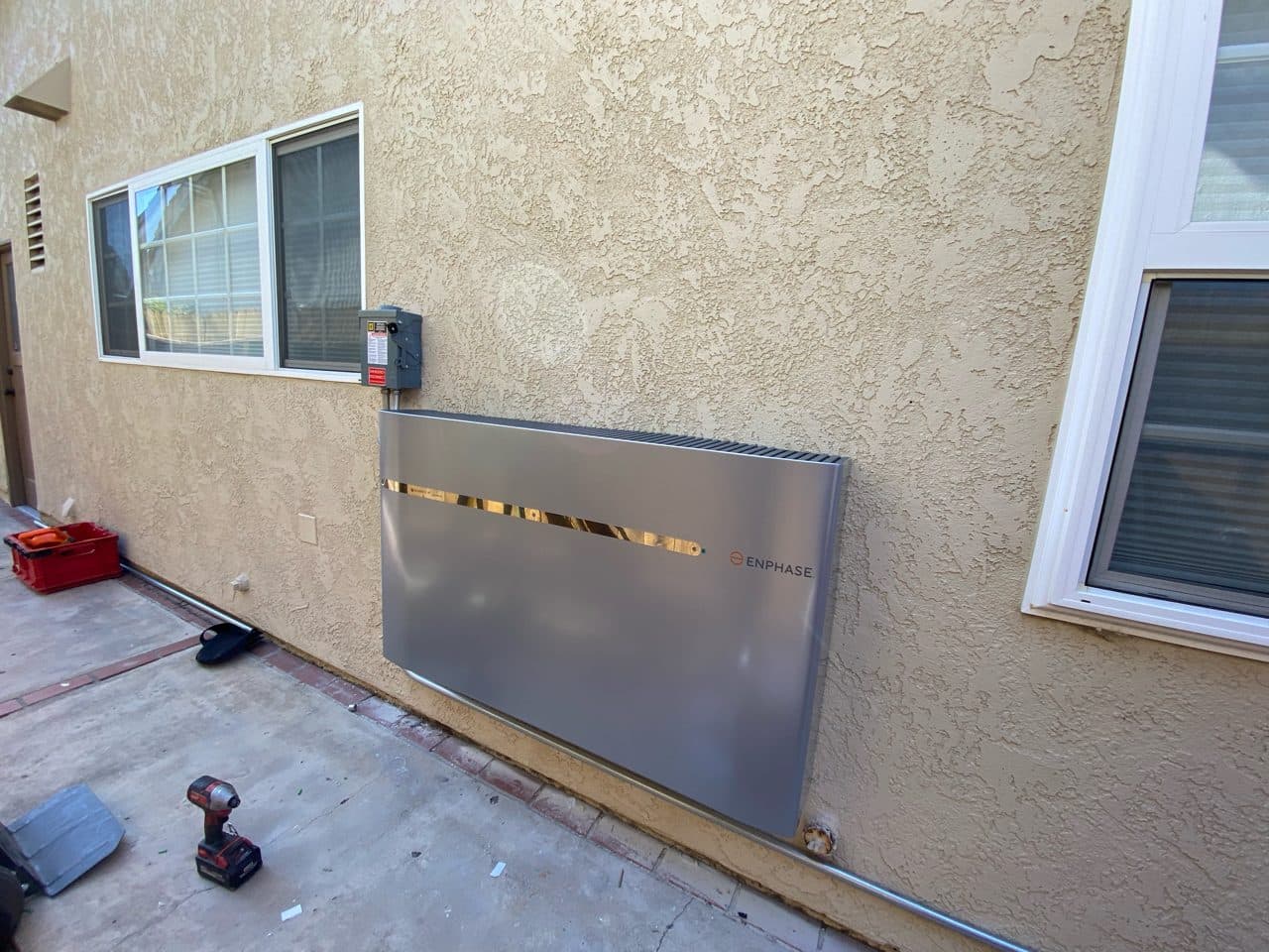 Enphase IQ home battery with disconnect installed on a stucco wall in Costa Mesa, CA