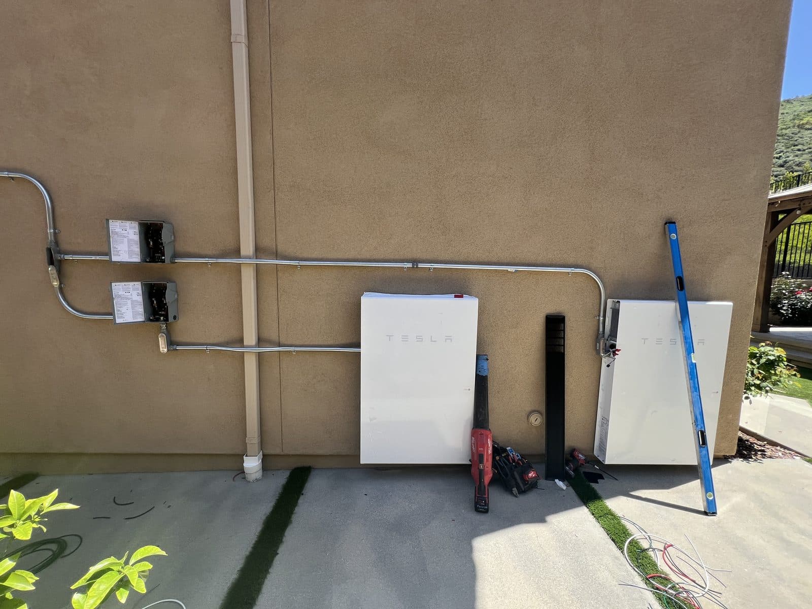 Two Tesla Powerwalls being installed on an exterior wall of a Hollywood Hills home in Los Angeles, CA